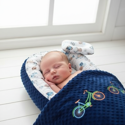 Bébé dormant dans le cocon bleu marine vélos
