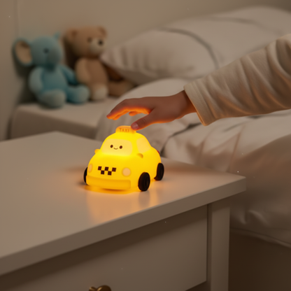 Main de bambin touchant une veilleuse taxi jaune kawaii posee sur table de nuit blanche dans chambre enfant cosy